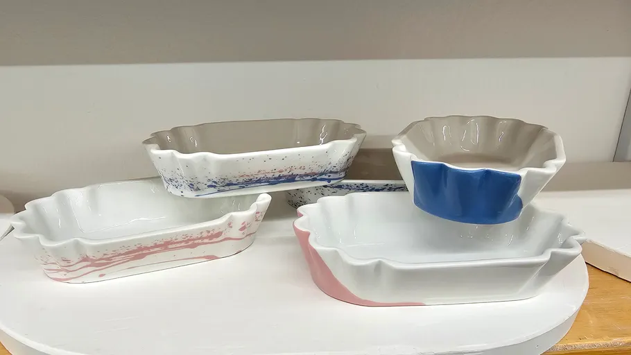 Keramikschalen mit verschiedenen Farben auf einem Regal.