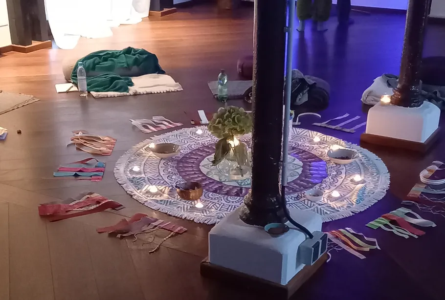 Candles and fabrics arranged on wooden floor.