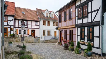 Bunte Fachwerkhäuser auf Kopfsteinpflasterstraße.