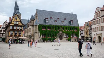 Menschen gehen auf historischem Platz in Deutschland.
