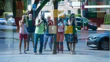 Gruppe fotografiert Spiegelung in buntem Fenster.