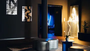 Modern living room with abstract art and neon light.