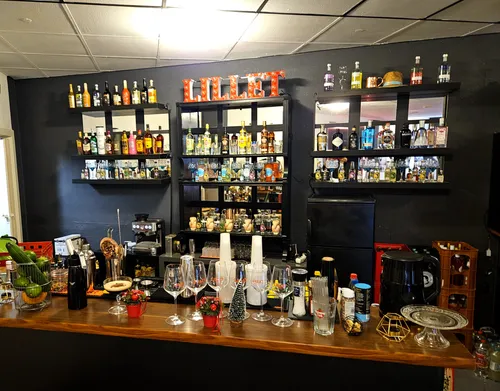 Bar counter with various bottles and glasses.