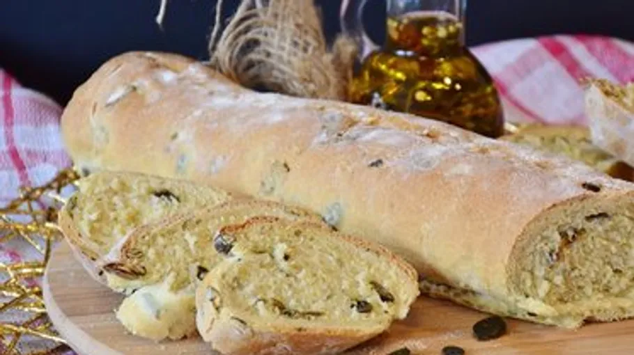 Bread loaf with slices on a wooden board.