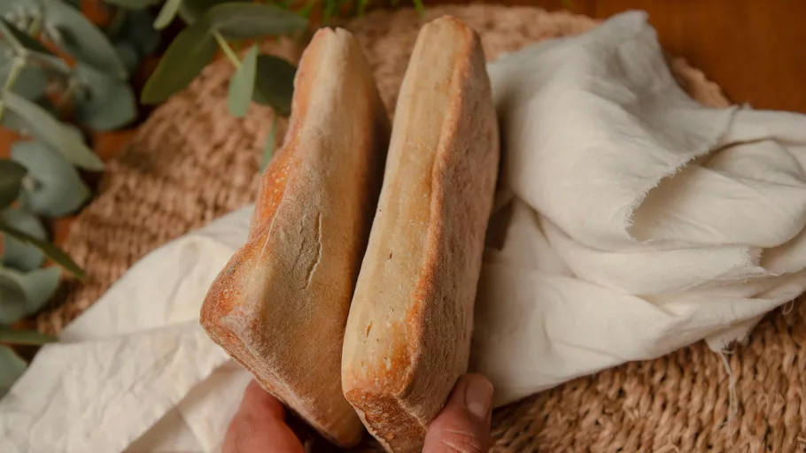 Two slices of bread held over basket.