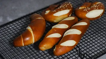 Pretzels and rolls cooling on a wire rack.