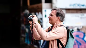Mann macht Foto in städtischer Umgebung.