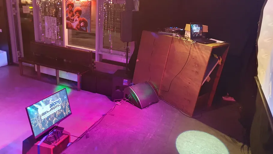 Stage setup with DJ booth and screens.