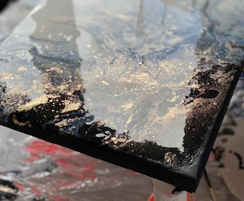 Abstraktes Gemälde mit Gold- und Schwarzmustern.