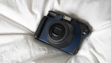 Fujifilm instant camera on white fabric.