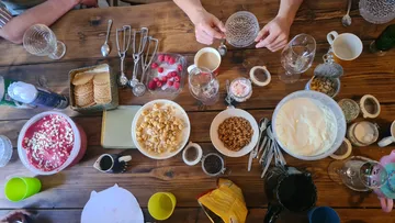 Tisch mit Desserts, Toppings und Händen