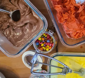 Ice cream tubs and candy on table.