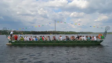 Grünes Boot mit Menschen auf einem See.