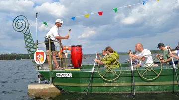 Menschen paddeln auf Drachenboot mit Trommler.