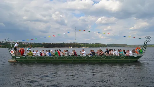 Long boat with people on a lake.