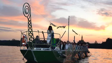 Gruppe auf einem Boot bei Sonnenuntergang auf einem See.