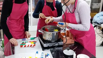 Menschen machen Kerzen in einem Workshop.
