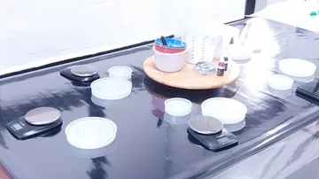 Waagen und Behälter auf einer reflektierenden Oberfläche.