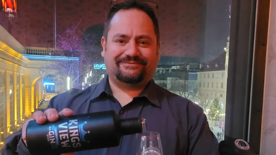 Mann gießt Gin in Glas bei Nacht.