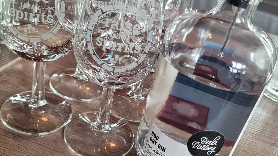 Glasses and gin bottle on wooden table.