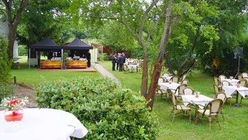 Outdoor event with tables and food stand.