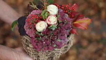 Herbststrauß mit Rosen und Beeren im Freien.