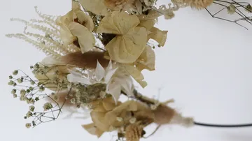 Getrocknete Blumen zu einem Kranz arrangiert.