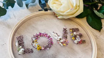 Floral letters spelling 'LOVE' in decorative hoop.