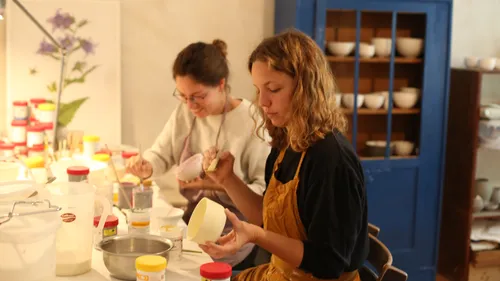 Zwei Frauen bemalen Keramik im Atelier.