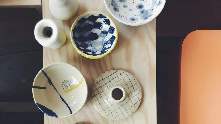 Ceramic bowls and vases on wooden surface.