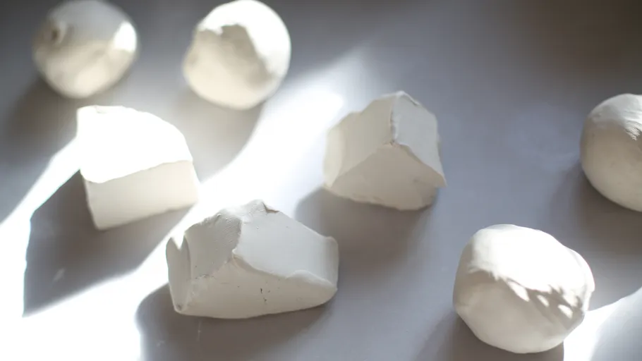 White clay shapes on a lit surface.