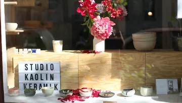 Ceramics and flowers in a shop window.