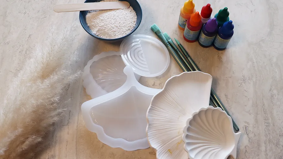 Kunstbedarf auf Tisch mit Muschelformen.