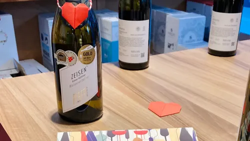 Weinflasche mit Herz, auf Holztisch.