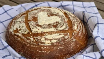 Round bread with heart design on cloth.