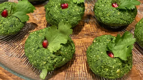 Green appetizers on glass plate, garnished with herbs.