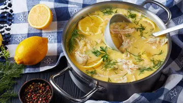 Topf mit Zitronensuppe auf kariertem Tuch.