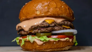 Doppel-Cheeseburger mit Belag auf Brötchen.