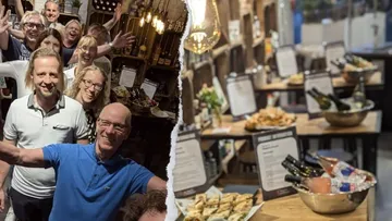Gruppe von Menschen lächelt drinnen; Buffet mit Weinflaschen.