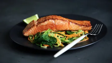 Gegrillter Lachs mit Gemüse auf Teller.