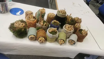 Handgemachte Bienenhäuser auf einem Tisch ausgestellt.