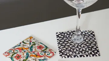 Glass on coaster, colorful napkin nearby.