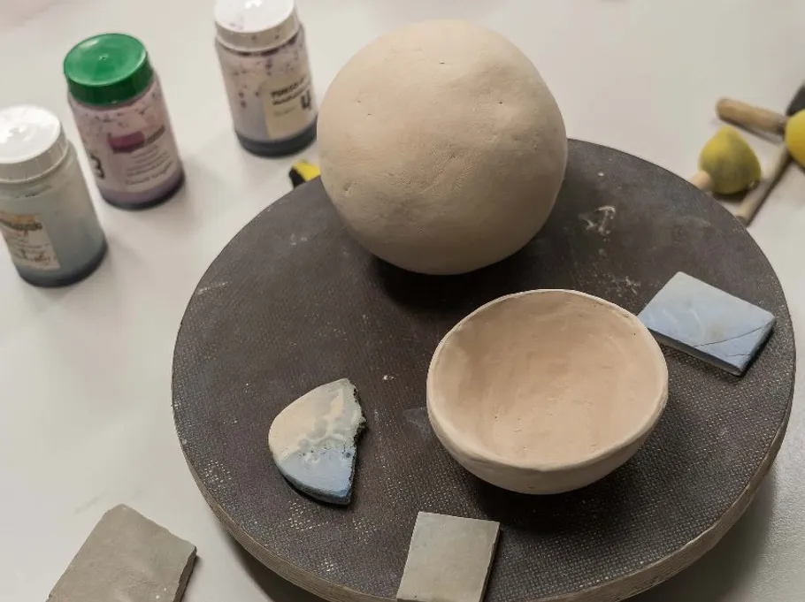 Clay objects and tools on crafting surface.