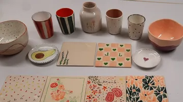 Assorted decorated pottery on white table.