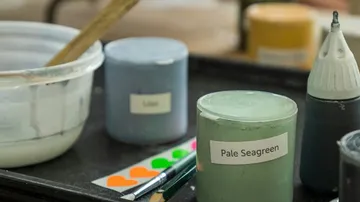 Farbe mit Etikett 'Pale Seagreen' und 'Blau' auf Tisch.