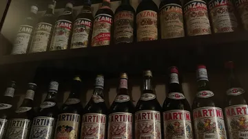 Flaschen von Cinzano und Martini auf Regalen.