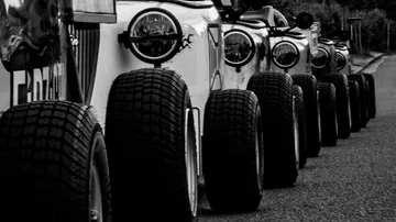 Row of parked off-road vehicles on road.