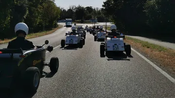 Mini cars driven on rural road.