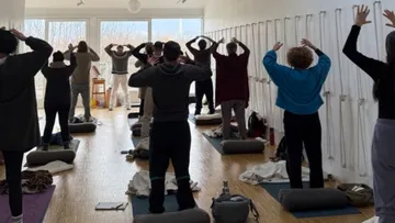 People doing yoga in a spacious room.