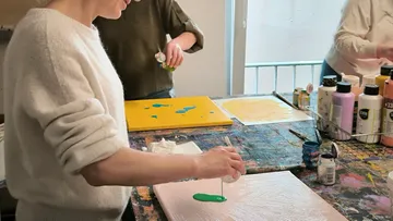 Menschen malen in einem Atelier.